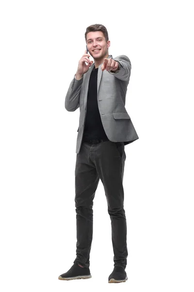 Handsome man talking to a mobile phone and pointing to a copy of the space — Stock Photo, Image