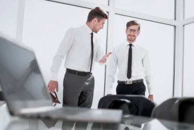 İki işadamı büyük pencerede el sıkışıyor.