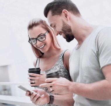 kahve içme ve Sms smartphone üzerinde okuma up.young çift kapatın.