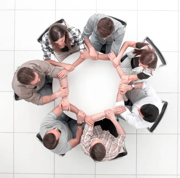 top view.The business team hold hands, forming a circle