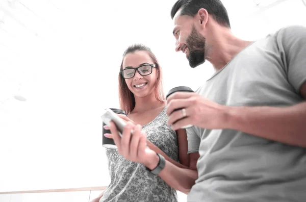 Pareja joven leyendo SMS en su teléfono inteligente — Foto de Stock