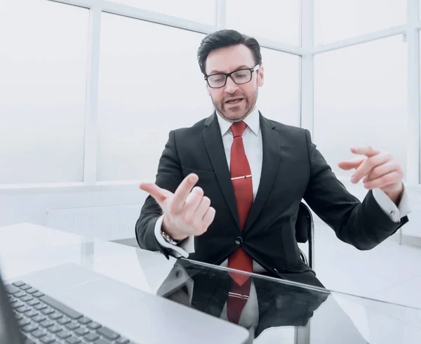 Businessman counts on his fingers, sitting at his Desk.