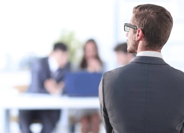 Bakifrån view.businessman står nära kontorsfönstret — Stockfoto