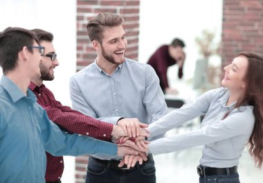 Bir grup insan, ortaklık takım çalışması için el ele tutuşuyor..