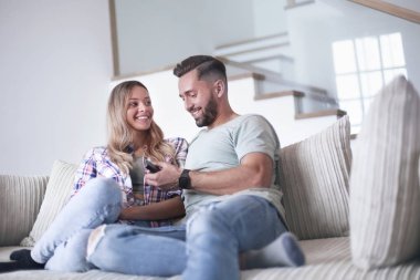 Sıcak oturma odasındaki kanepede oturan sevgili çift.