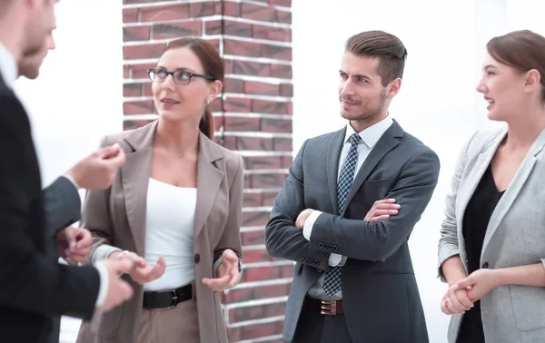 Equipo de negocios discute sus ideas de pie en el pasillo de la oficina . —  Fotos de Stock