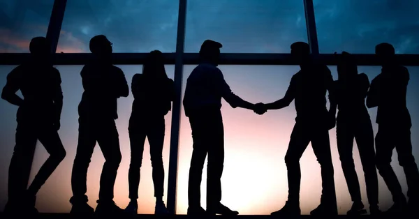 Apretón de manos de los socios comerciales en el fondo de la ventana de la oficina — Foto de Stock