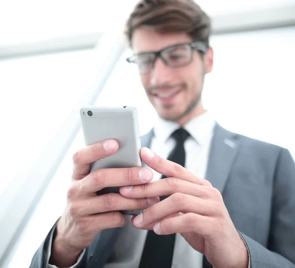 Zakenman kijken naar mobiele telefoon in kantoor — Stockfoto