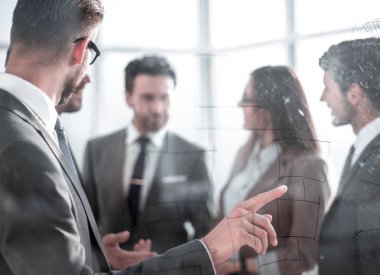 Genç adam akış çizelgesi cam tahtada çizim