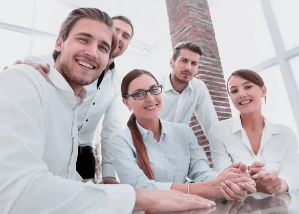 Retrato de un equipo positivo sentado en una mesa —  Fotos de Stock