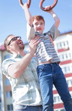 Baba oğlu bar yetişmek için yardımcı olur.