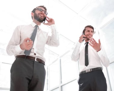 alt view.two başarılı işadamları kendi akıllı telefonlar üzerinde konuşuyor.