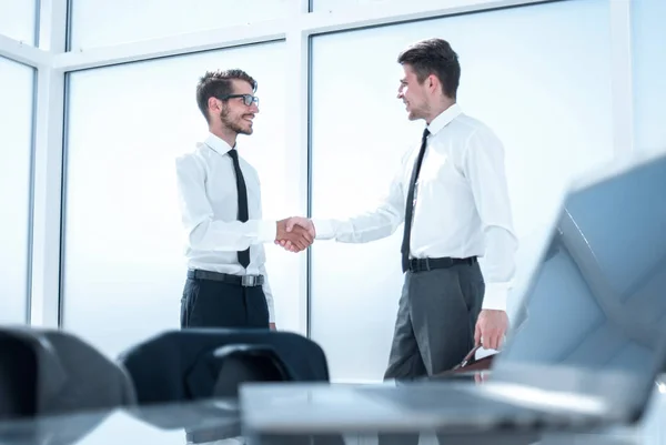 Due uomini d'affari che si stringono la mano davanti a una grande finestra — Foto Stock