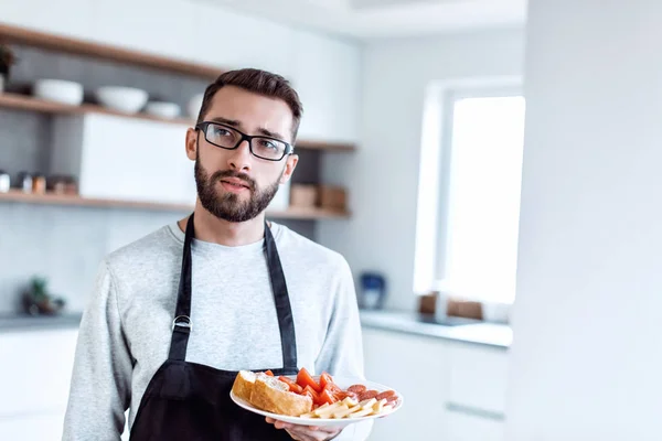 Egy tál szendvics egy vonzó férfi kezében. — Stock Fotó