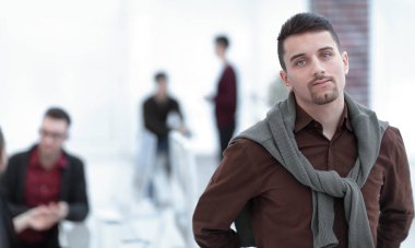 Kendine güvenen genç adam ofis arka planda.