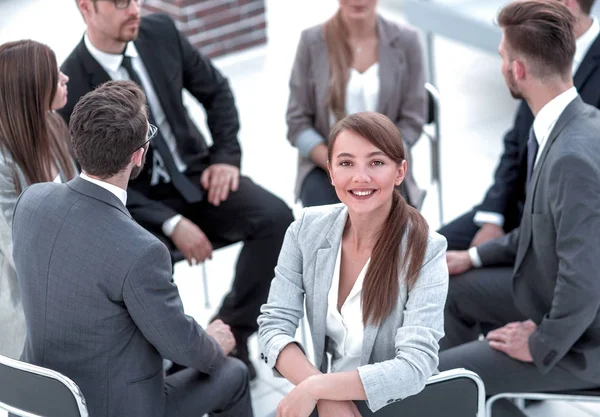 Joven mujer de negocios sentada en un círculo de colegas — Foto de Stock