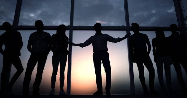 Líder y el equipo de negocios en el fondo de la ventana de la oficina — Foto de Stock