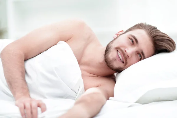 Glücklicher Mann, der in einem bequemen Bett einschläft — Stockfoto