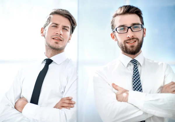 Sorrindo colegas de negócios em pé em um escritório brilhante — Fotografia de Stock