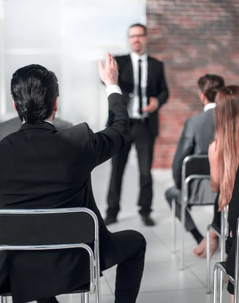 Hombre de negocios respondiendo preguntas de los empleados en una reunión de negocios — Foto de Stock