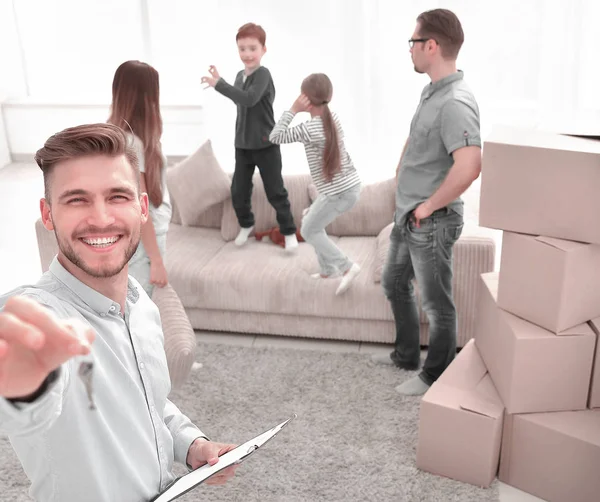 Sorrindo corretor de imóveis com área de transferência mostrando chaves para novo apartamento — Fotografia de Stock