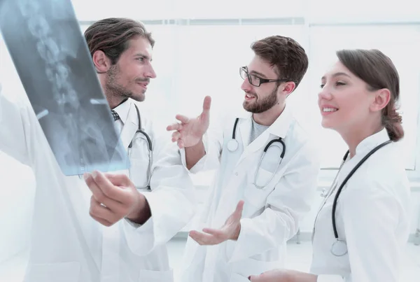 Três médicos confiantes examinam um raio-X — Fotografia de Stock