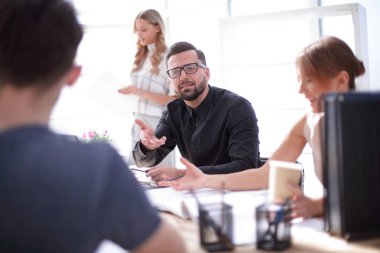 yeni bir proje için fikirleri tartışan çalışanlar.