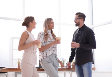 İş ekibi ofiste duran bir şeyi tartışıyor.