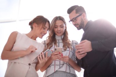 İş ekibi akıllı telefonlarının ekranlarına bakıyor.