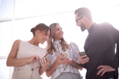 İş ekibi akıllı telefonlarının ekranlarına bakıyor.