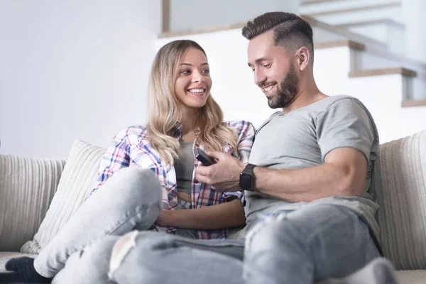 Kärleksfullt par sitter på soffan i mysigt vardagsrum — Stockfoto