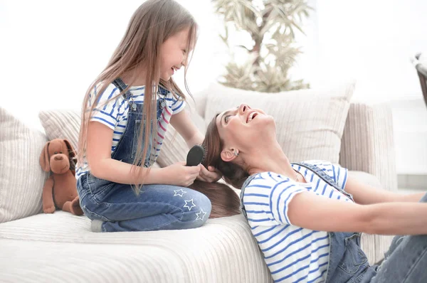 小女孩梳她母亲的头发 — 图库照片