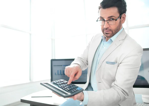 Homem de negócios confiante apontando para calculadora — Fotografia de Stock