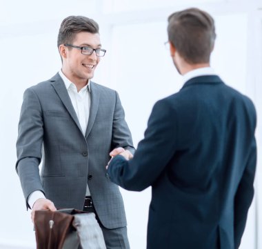 İş adamları birbirlerini tokalaşarak selamlıyorlar.