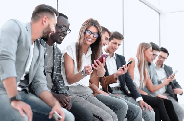group of young people looking at the screens of their smartphones