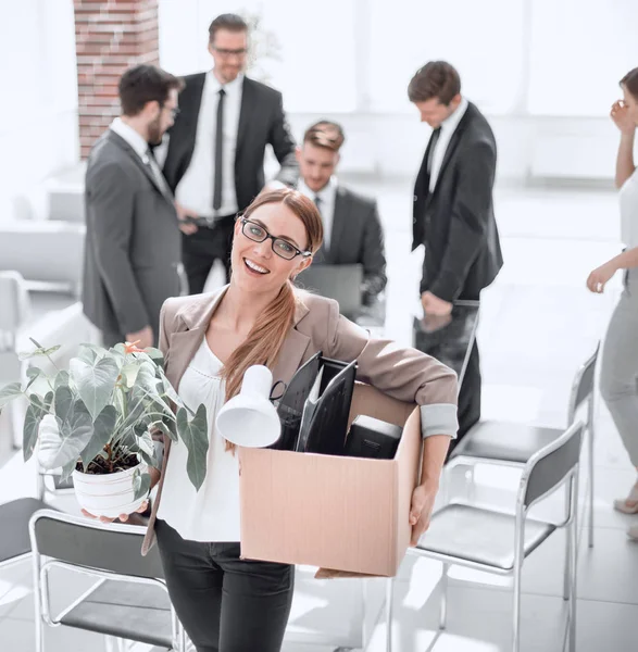 Sonriente mujer de negocios con cosas personales de pie en la oficina moderna — Foto de Stock