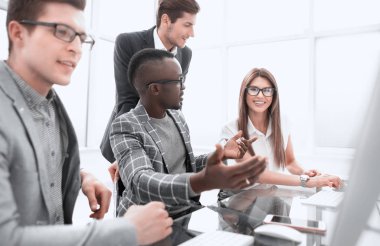 Çalışanlar masada oturmuş yeni fikirleri tartışıyor.