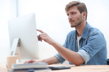 ofiste bir bilgisayar üzerinde çalışan iş adamı