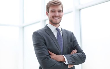 yakın çekim.ciddi genç işadamı ofiste ayakta.