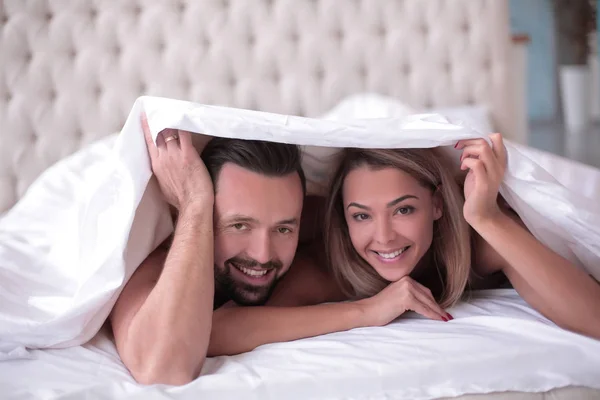 Söta kärleksfulla par som ligger under filten — Stockfoto