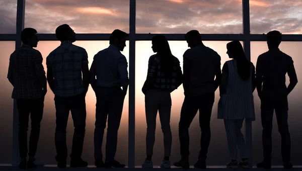 Equipo de negocios hablando de pie cerca de una gran ventana — Foto de Stock