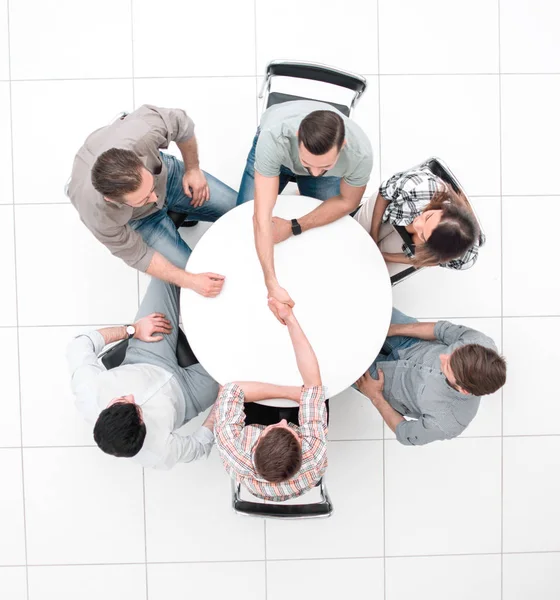 Top view. handshake colleagues at the round table. — Stock Photo, Image