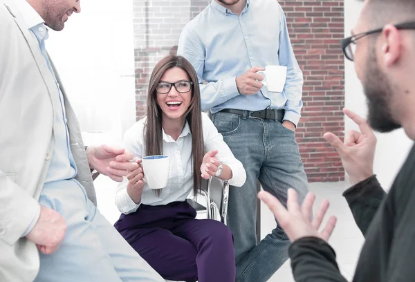 Бізнес команда розмовляє і посміхається під час кавової перерви в офісі — стокове фото