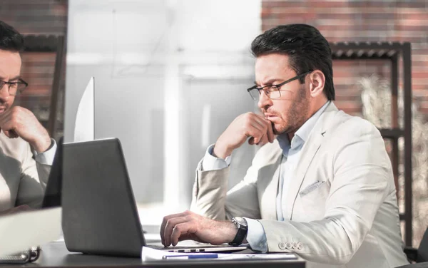 Geschäftsmann denkt im Büro hinter einer Glaswand. — Stockfoto