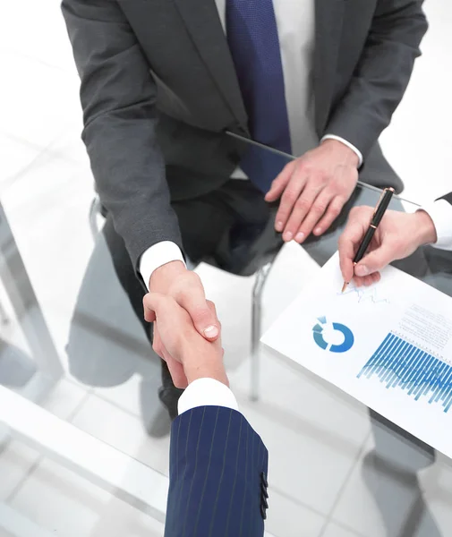 Aperto de mão dos parceiros financeiros no Desk — Fotografia de Stock