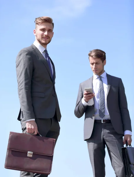 Два современных бизнесмена, стоящих на улице — стоковое фото