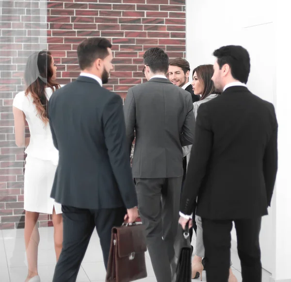 Gruppo di uomini d'affari che parlano, in piedi nella hall del business center . — Foto Stock