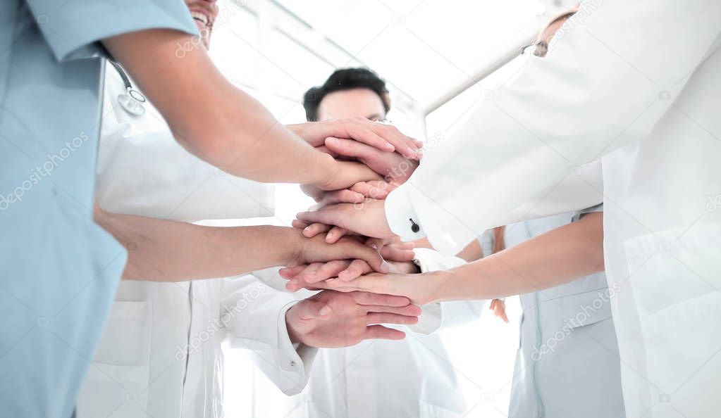 group of doctors with their hands folded together