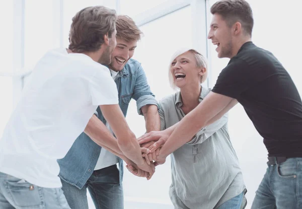 Puesta en marcha. compañeros de trabajo felices poniendo sus manos juntas — Foto de Stock