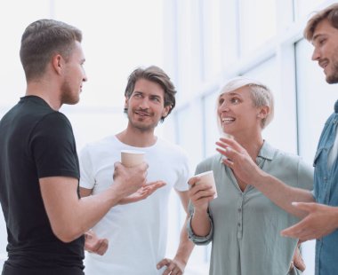 iş arkadaşlarından oluşan bir grup ofis koridorunda bir şey tartışıyorlar